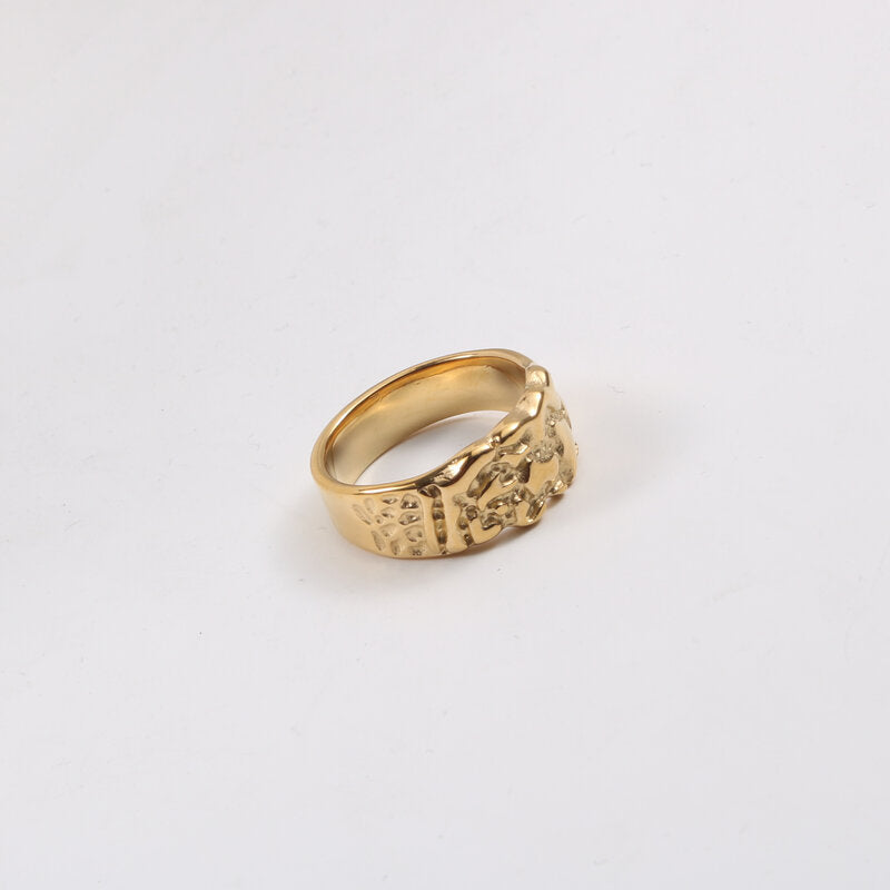 Wide gold band ring with a rough nugget-textured front tapering to a plain polished shank at the back