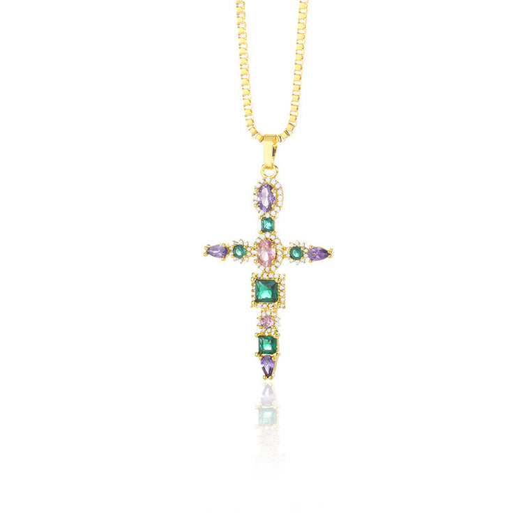Four dainty gold cross necklaces: thin minimal cross, heart-link cross, petal-point cross, and a colored-stone cross