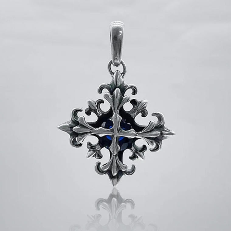 Darkened silver-tone gothic cross pendant with fleur-de-lis points and a deep blue faceted center stone