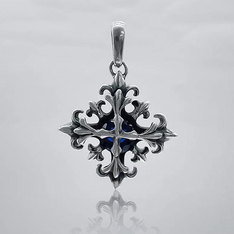 Darkened silver gothic cross pendant with fleur-de-lis points and a deep blue faceted center stone
