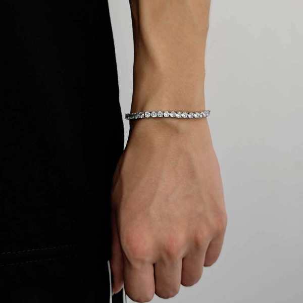 Single-row cubic zirconia tennis bracelet shown on a wrist, in gold-tone and silver-tone, widths 3 to 5 millimeters