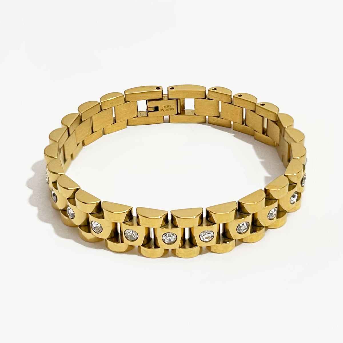 Five-row link band bracelet with a round clear stone set into every center link, shown in gold and in steel