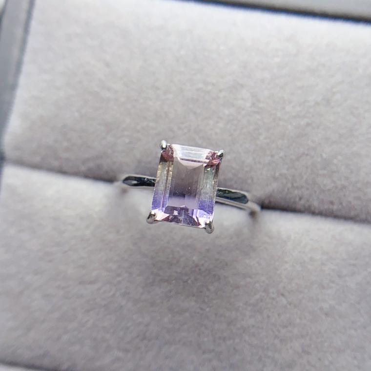 Thin silver-tone ring with a rectangular pale purple-and-yellow step-cut stone in four prongs