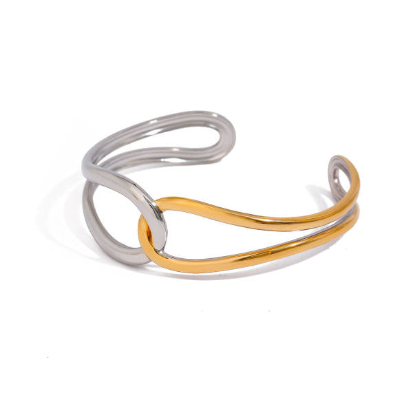 Open cuff bracelet of two sculptural loops, one silver-tone and one gold-tone, interlocked at the center